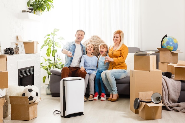 Luftreiniger im Wohnzimmer mit glücklicher Familie, die in eine neue Wohnung zieht