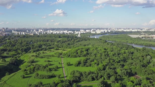 Luftszene mit riesigen Grünflächen und Flüssen, die durch die Stadt fließen, Wohnhäuser in der Ferne. Moskau, Russland