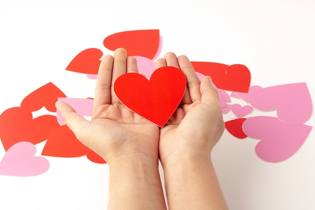 Lugar de artesanía de papel en forma de corazón rojo a mano aislado, artesanía de papel en forma de corazón rojo y rosa está dispersa, concepto de amor y día de San Valentín.