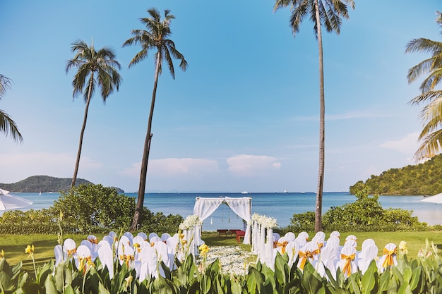 Lugar de celebración de la boda en la playa con palmera de coco y vista panorámica al mar