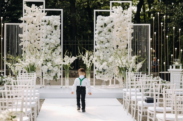 Un lugar para una ceremonia de boda en la calle y un niño caminando por el sendero. Lugar de boda decorado