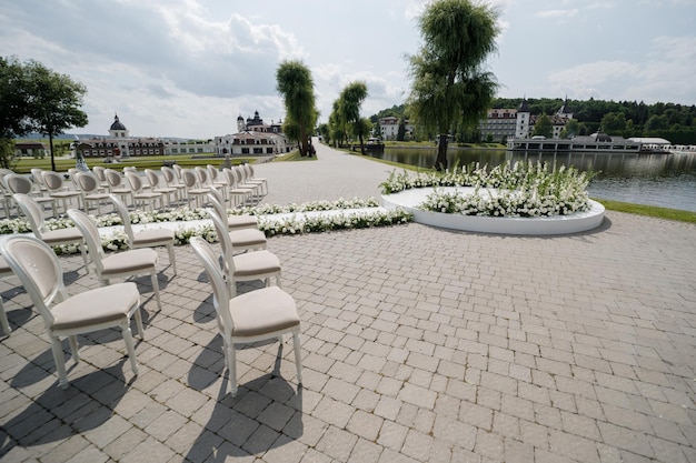 Lugar para la ceremonia de boda en el jardín al aire libre espacio de copia Arco de boda decorado con flores y sillas a cada lado del arco Entorno de boda