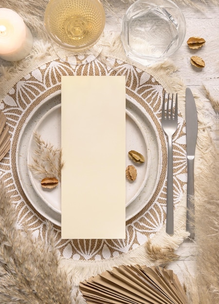 Foto lugar de mesa de casamento com cartão em branco vertical no prato na vista superior do boêmio placemat