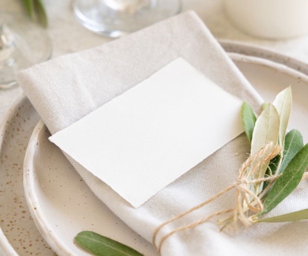 Lugar de mesa de boda con tarjeta decorada con ramas de olivo