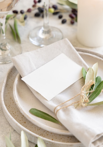 Lugar de mesa de boda con una tarjeta decorada con ramas de olivo