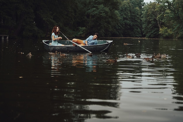 Lugar perfeito para fugir. Jovem casal lindo sorrindo e alimentando os patos