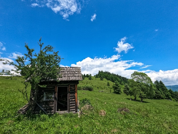 Lugar remoto em uma colina verde com uma velha cabana de madeira