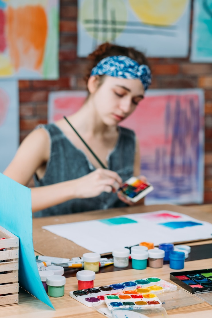 Foto lugar de trabajo del artista. joven pintora creando obras de arte abstractas en estudio