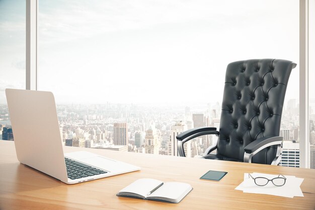 Lugar de trabajo de la cabeza con una computadora portátil y un sillón de cuero clásico.