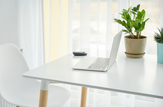 Lugar de trabajo con computadora portátil Cómoda mesa de trabajo en las ventanas de la oficina y vista a la ciudad.