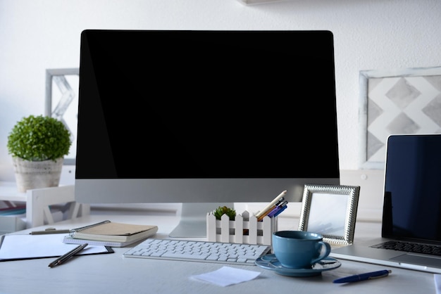 Lugar de trabajo con computadora y portátil en la mesa