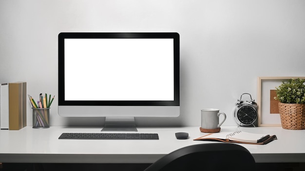 Foto lugar de trabajo contemporáneo con computadora pd taza de café planta de interior y papelería en mesa blanca