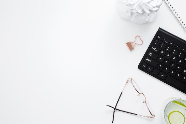 Lugar de trabajo con cuaderno blanco, teclado negro, papelería, escritorio de oficina plano, espacio simulado para texto