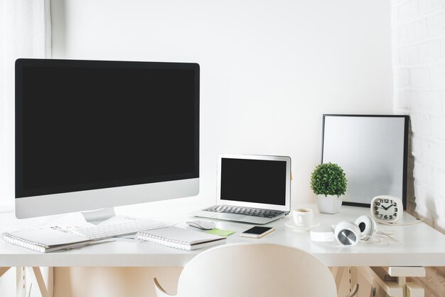 Lugar de trabajo de diseñador blanco con computadora y computadora portátil