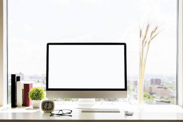 Lugar de trabajo de diseñador con monitor en blanco