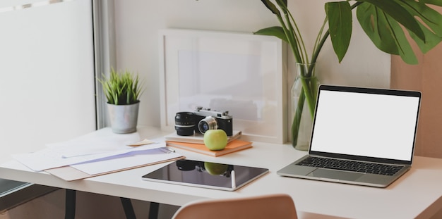 Lugar de trabajo de diseño moderno con computadora portátil de pantalla en blanco