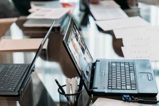 Lugar de trabajo empresarial Tecnología de la comunicación Teletrabajo corporativo Equipo profesional que trabaja en línea en una oficina virtual en la pantalla de un portátil en una mesa de conferencias