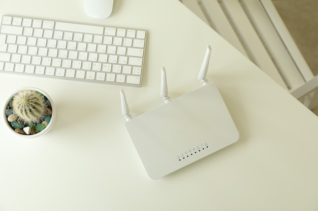 Lugar de trabajo con enrutador Wi - Fi en mesa blanca