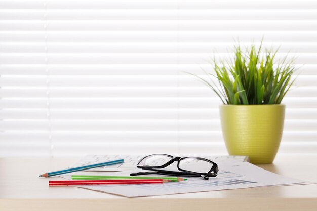 Lugar de trabajo de escritorio de oficina con suministros y planta.