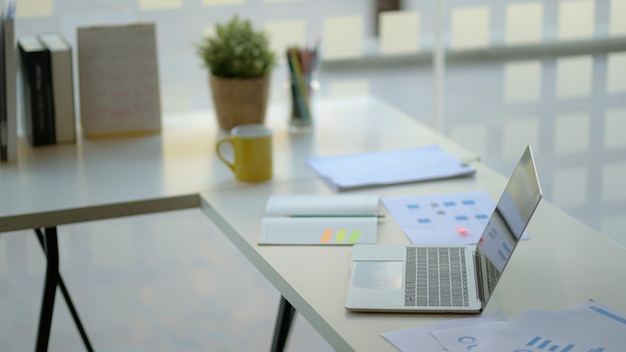 Lugar de trabajo con laptop, material de oficina y café.