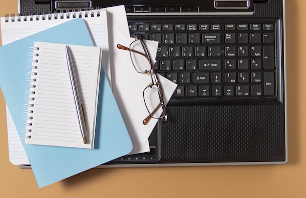 Foto lugar de trabajo con laptop, notebook y gafas