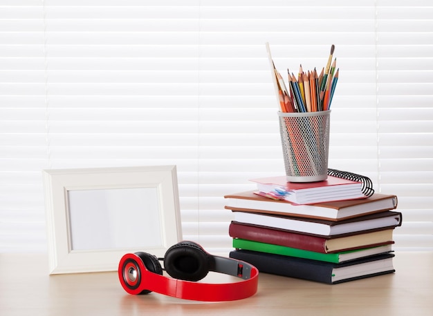 Lugar de trabajo con libros de auriculares de marco de fotos.