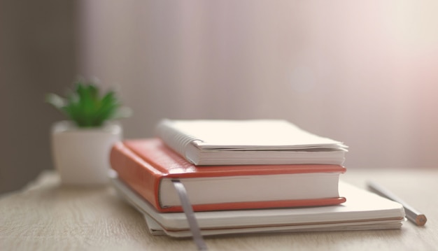 Lugar de trabajo. Libros, cuadernos en la mesa frente a la ventana. Teletrabajo Trabajar en casa.