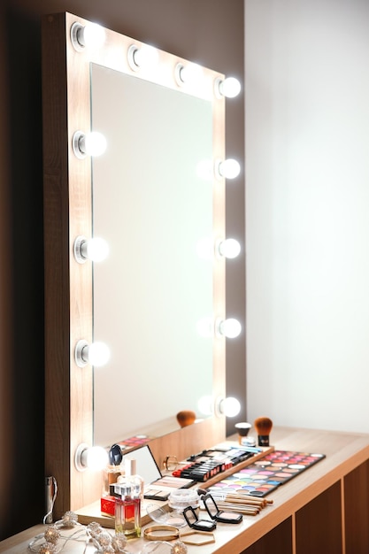 Lugar de trabajo de maquillador profesional con espejo grande y cosmético.
