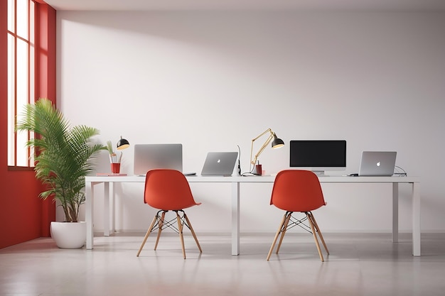 Lugar de trabajo moderno con dos portátiles sobre una mesa roja contra una pared blanca