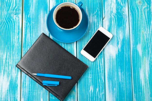 Lugar de trabajo moderno con taza de café en la mesa de madera