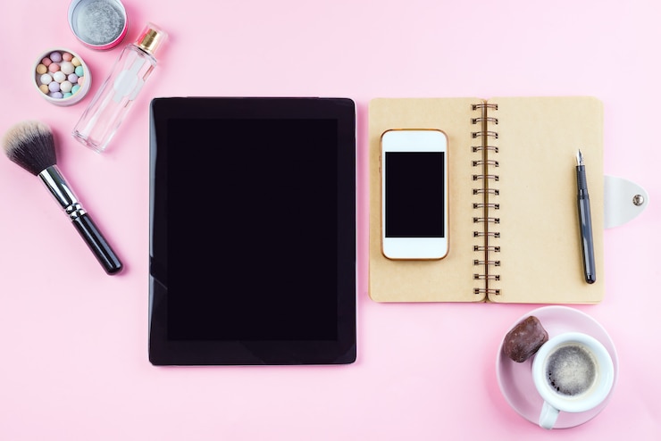 Foto el lugar de trabajo de la mujer con café, tableta, teléfono y cosméticos.