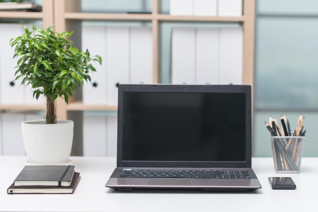 Lugar de trabajo de oficina con cuaderno en mesa de madera