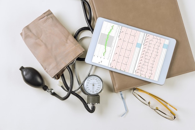 Lugar de trabajo de oficina médica con un gráfico de cardiograma estetoscopio con mesa médica para registro cardíaco pa