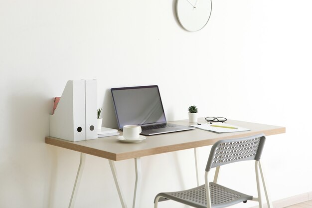 Lugar de trabajo con portátil moderno en el interior de la habitación.