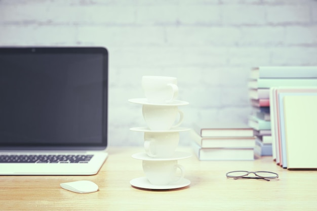 Lugar de trabajo con torre de tazas de café.