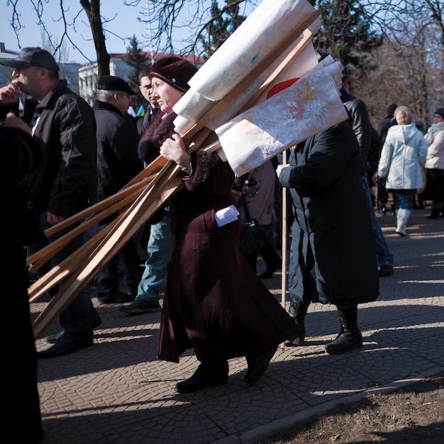 LUHANSK, UCRÂNIA - 5 DE ABRIL DE 2014 Um velho ativista pró-russo em um comício, carrega bandeiras na mão