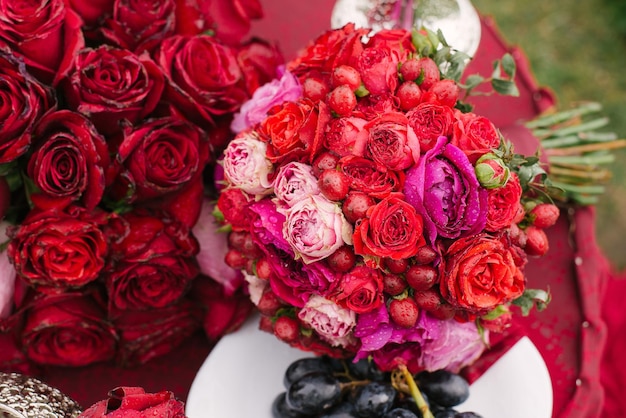 Lujoso y brillante ramo de bodas de la novia con flores rojas y rosas, rosas y bayas