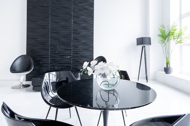 Lujoso interior moderno futurista de moda en colores contrastantes en blanco y negro con interesantes muebles negros de moda y paredes decoradas