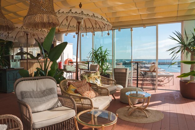 Lujoso salón de estilo Marrakech con vista a la piscina y muebles de mimbre