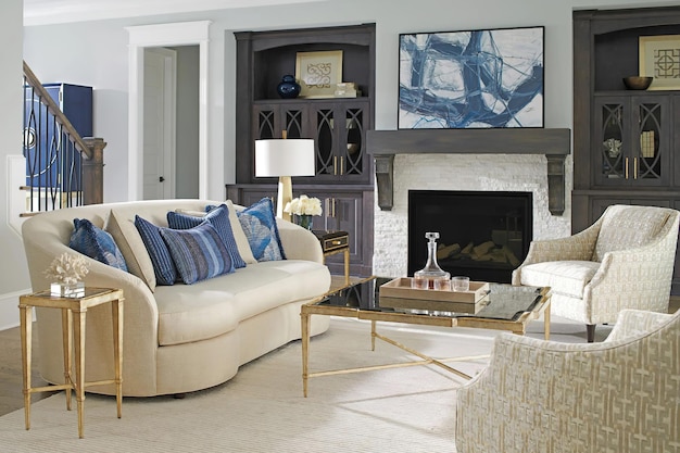 Lujoso salón interior con sofá blanco, almohadas azules, mesa de diseño con superficie de vidrio y chimenea