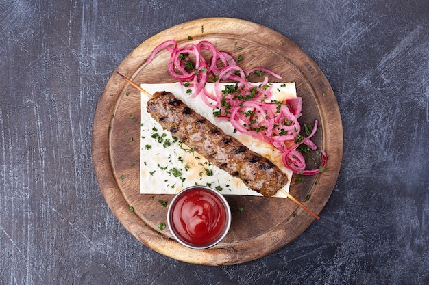 Lula kebab con cebolla roja y ensalada, plato tradicional del Cáucaso.