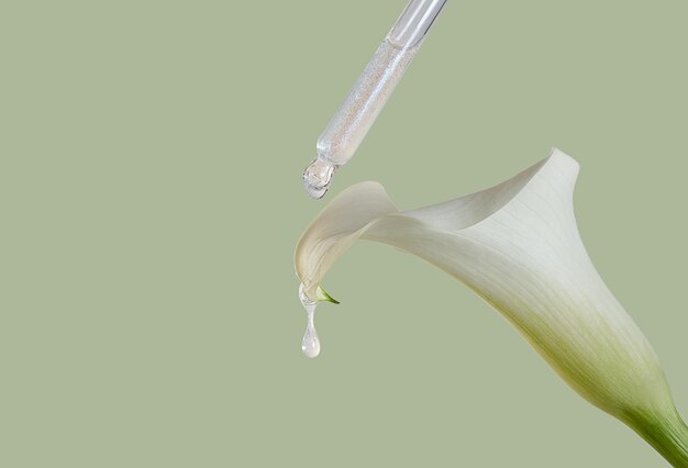 Foto luminosas y lujosas gotas plateadas y blancas de resaltador líquido que gotean de la hoja de calla