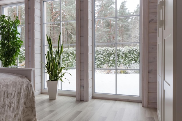 Luminoso interior de estudio fotográfico con gran ventanal, techo alto, suelo de madera blanca