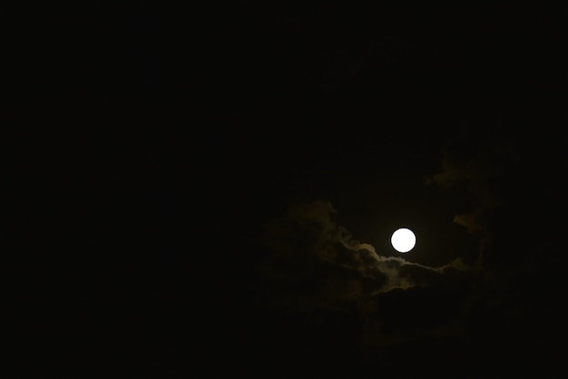 La luna brilla a través de las nubes en el cielo por la noche.