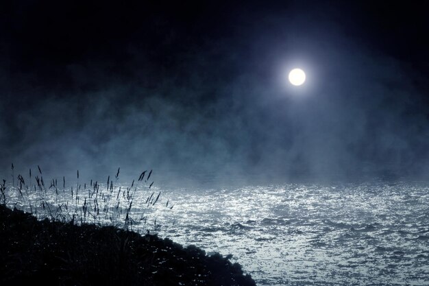 Luna brillante en el cielo nocturno sobre el río