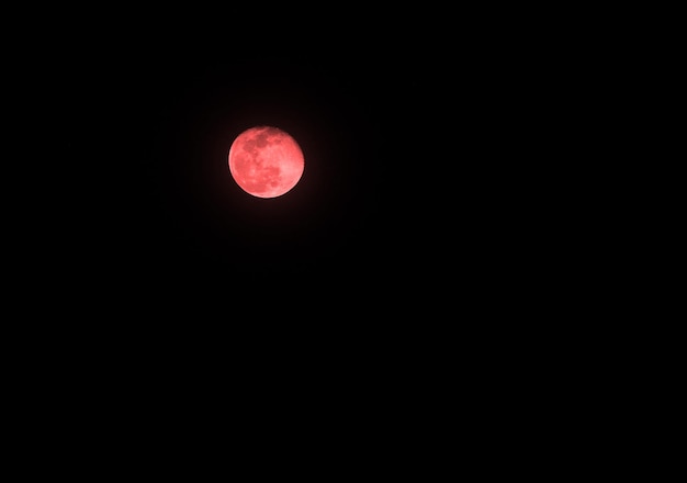 Luna con color en el cielo oscuro por la noche y fondo negro aislado.