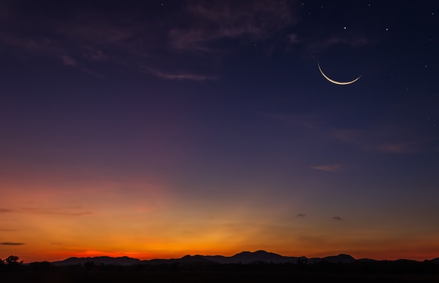 Luna creciente en el cielo azul oscuro del atardecer en la noche