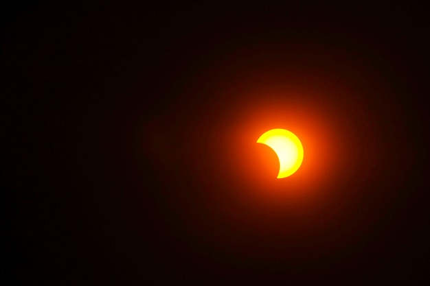 La Luna cubriendo el Sol en una ramita de sombra de eclipse parcial.