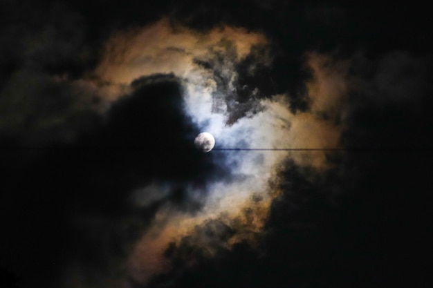 Una luna es visible a través de las nubes en el cielo.