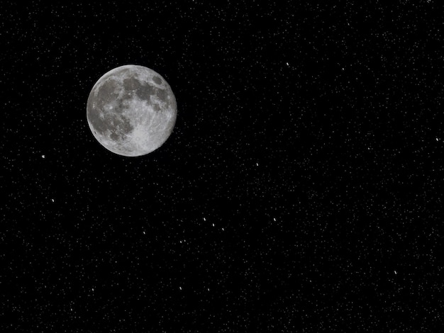 Luna llena en el cielo negro estrellado negro en la noche